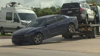 Dark blue car, police vehicle towed from scene of double fatal shooting at Houston motel