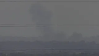 Aid air drops over Gaza Strip, smoke plume in distance