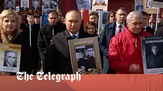 Putin leads Immortal Regiment parade with a photo of his father