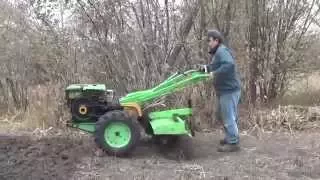 Diesel walk-behind tractor. Work cutter on solid ground.