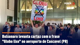 Bolsonaro levanta cartaz com a frase "Globo lixo" no aeroporto de Cascavel