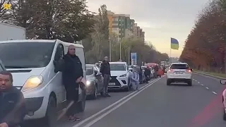 Ukrainians kneel on road as their fallen heroes return home