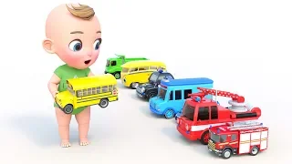Un niño pequeño se juega con coches de juguete. Camión de bomberos, autobús escolar y ambulancia