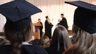 Many people at ceremony to celebrate graduation. Dean shaking student's hand. Stock Footage