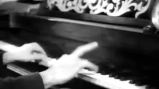 Chico Marx plays the piano with an apple