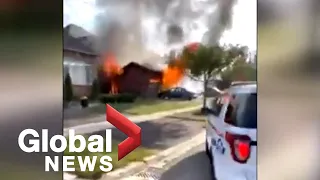 Video shows contractors take action after woman drives into home, sets car on fire