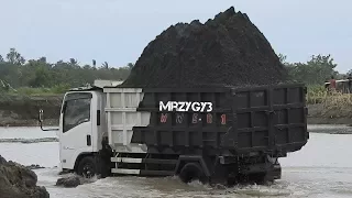 Overloaded Dump Truck On The River By Kobelco SK200-10 Keihatsu 921C Excavator