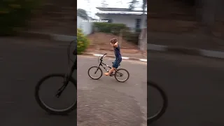 João andando de bike sem as mãos.