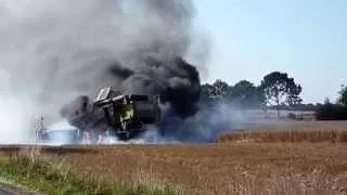 Burning Claas combine harvester sets fire to crops.