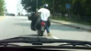 Man on scooter carrying 3 tires...