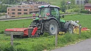 Traktor pflückt Gras und packt es mit der Maschine in der Schweiz