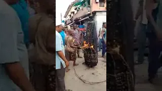 African Masquerade parade in Nigeria, egungun sitting inside fire