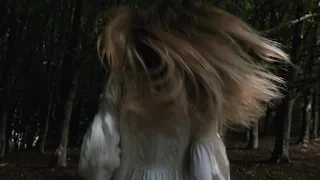 Woman running in a dark forest