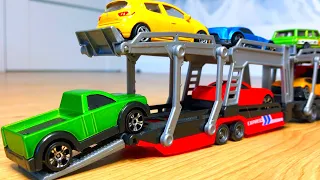 Small diecast model cars being carried by transportation vehicles