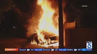 EV goes up in flames, scorches building in Granada Hills