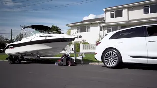 An Audi e-tron towing a boat.