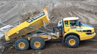 Volvo A45G articulated haulers dumping rock- D8T Dozer pushing away