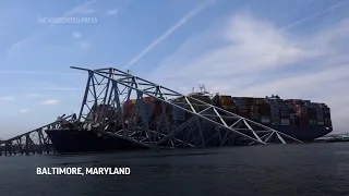 View of cargo ship and collapsed Baltimore bridge from Coast Guard boat as recovery effort continues