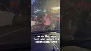 Woman tries to stand in a parking spot to save it for her boyfriend.