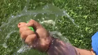 Slow-mo water balloon burst in hand