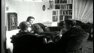 A woman operates a radio and other members of the family listen to it in the Unit...HD Stock Footage