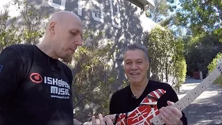 Eddie Van Halen autographs a guitar infront of 5150 Studio