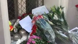 Люди несут цветы к посольствам Малайзии и Голландии