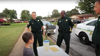 Junge verkauft Limonade und wird von der Polizei umzingelt