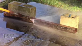 Pressure washing a filthy landscape timber