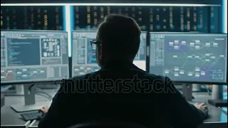 stock footage professional it programer working in data center on desktop computer with three displa