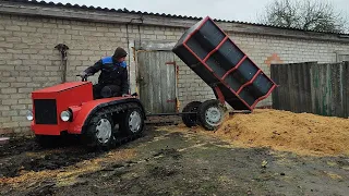 Гусеничный минитрактор помогает по хозяйству.