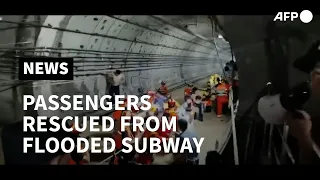 Firefighters rescue trapped passengers from flooded subway in China | AFP