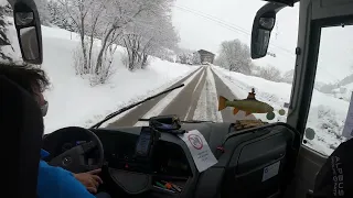 Bus driving downhill a snowy mountain, French Alps