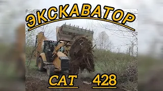 ЭКСКАВАТОР- погрузчик Cat 428 вытаскивает пень.Wheeled excavator  428 pulls out a large tree stump