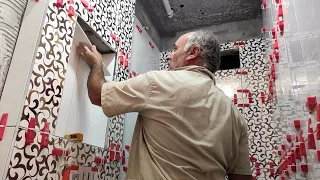 This master knows his job! He places the ceramics on the wall professionally!