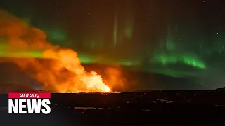 Northern lights appear over erupting volcano in Iceland