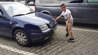Two kids pushing a car.