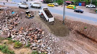 Perfectly Action! Installing first foundation road by cat bulldozer d4c & tipper trucks unloading