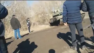 Brave Unarmed Ukrainian citizens blocking road and forcing Russian Army tanks to turn around.