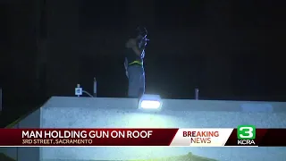 Man With Gun On DOCO Roof