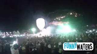 Un globo lleno de fuegos artificiales explota sobre miles de personas