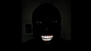 Black man smiles laughing dark room