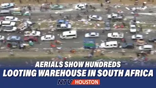 Aerials show hundreds looting warehouse in South Africa