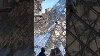 Climate activists scale Louvre pyramid and spray it with orange paint