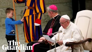 Pope Francis chuckles as boy climbs on stage and interrupts speech