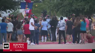 The community gathers at a memorial to remember those lost in the Allen outlet mall shooting