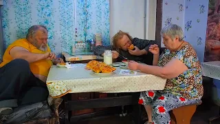 Деревенская дружная семья обедает и завтракает за столом едим домашние пирожки с картофелем