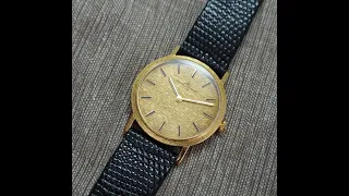 c1966 Baume & Mercier 18k gold men's vintage dress watch with textured dial and case.