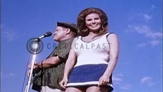 Bob Hope and Racquel Welch dance and sing at camp Enari in Pleiku, South Vietnam. HD Stock Footage