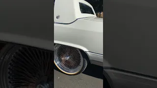 Cadillac brougham on 22 inch spokes and vogues